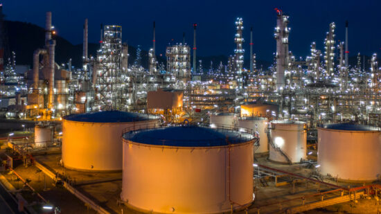 Aerial view. Oil refinery factory and oil storage tank at twilight and night. Petrochemical Industrial.